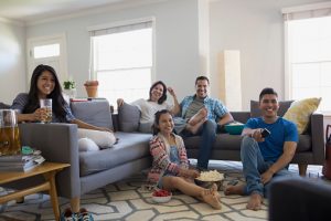 Family watching TV with popcorn in living room